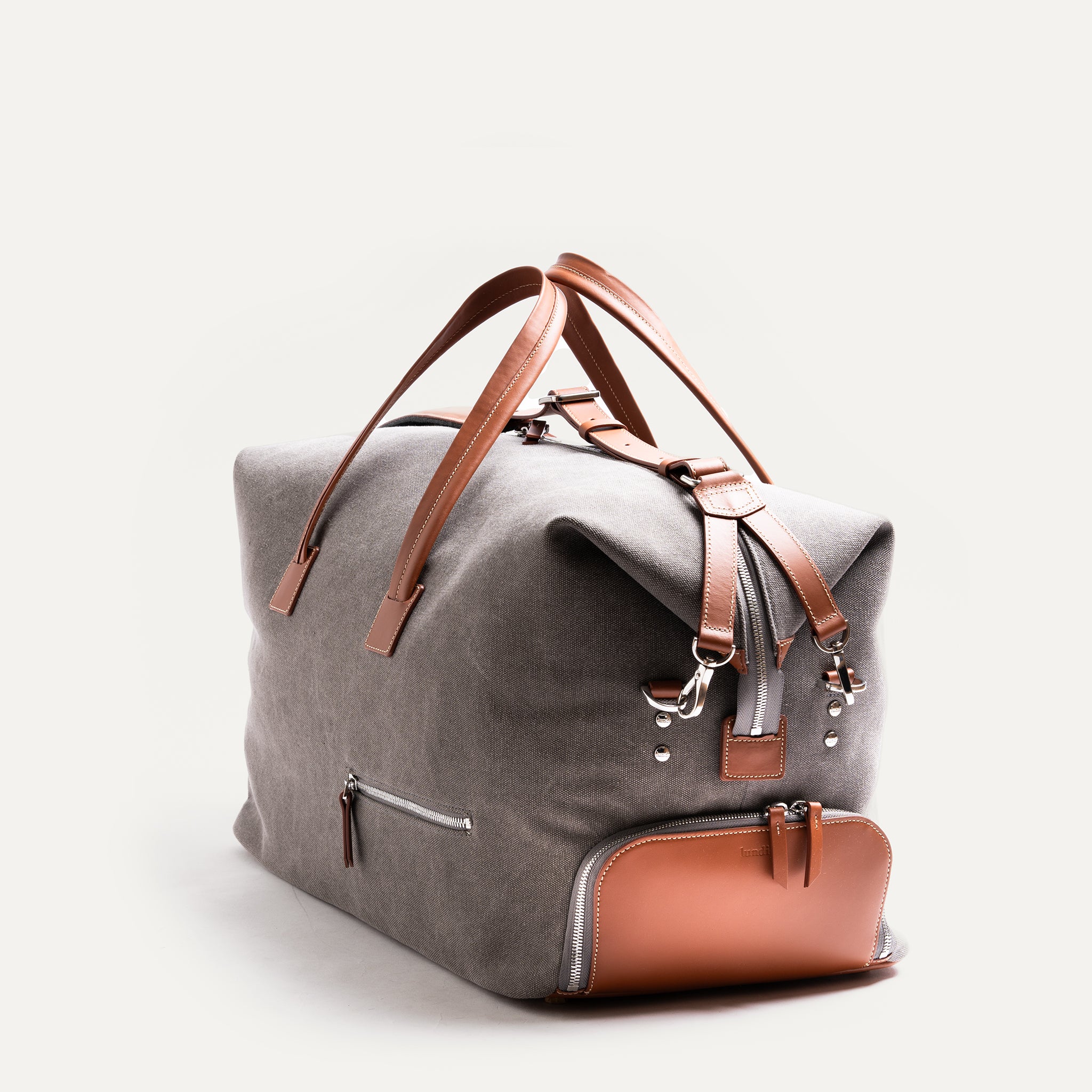 Découvrez notre sac de voyage gris et Cognac en toile et cuir, un mélange parfait de style et de fonctionnalité. Avec ses accents en cuir et ses poignées robustes, il est idéal pour tous vos voyages pour ranger tout vos vêtements.