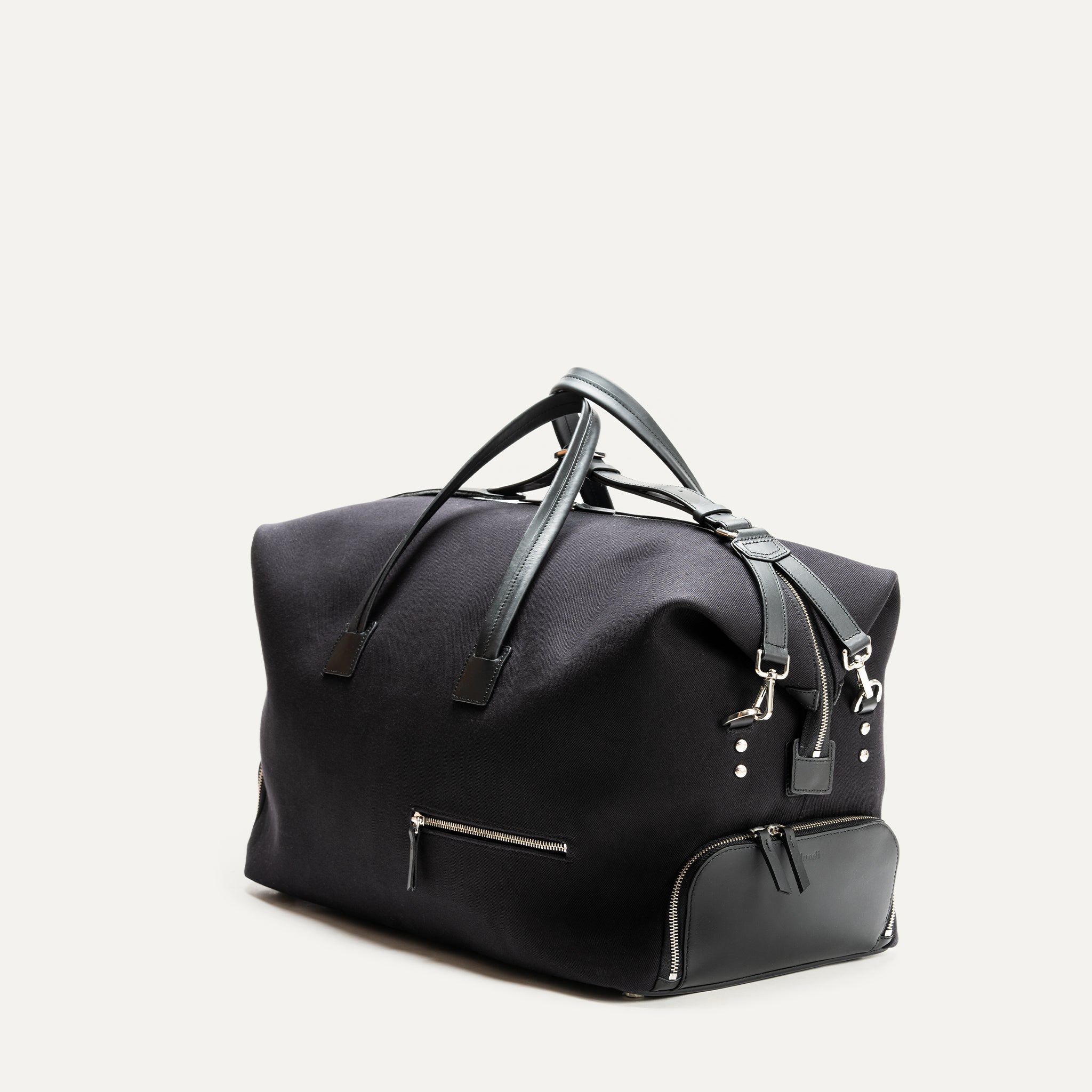 Voyagez en toute élégance avec ce sac de voyage noir en toile résistante. Il dispose de poignées en cuir pour un transport confortable et de poches extérieures pour une organisation facile. Sa grande capacité de rangement le rend idéal pour les courts séjours et les voyages d'affaires